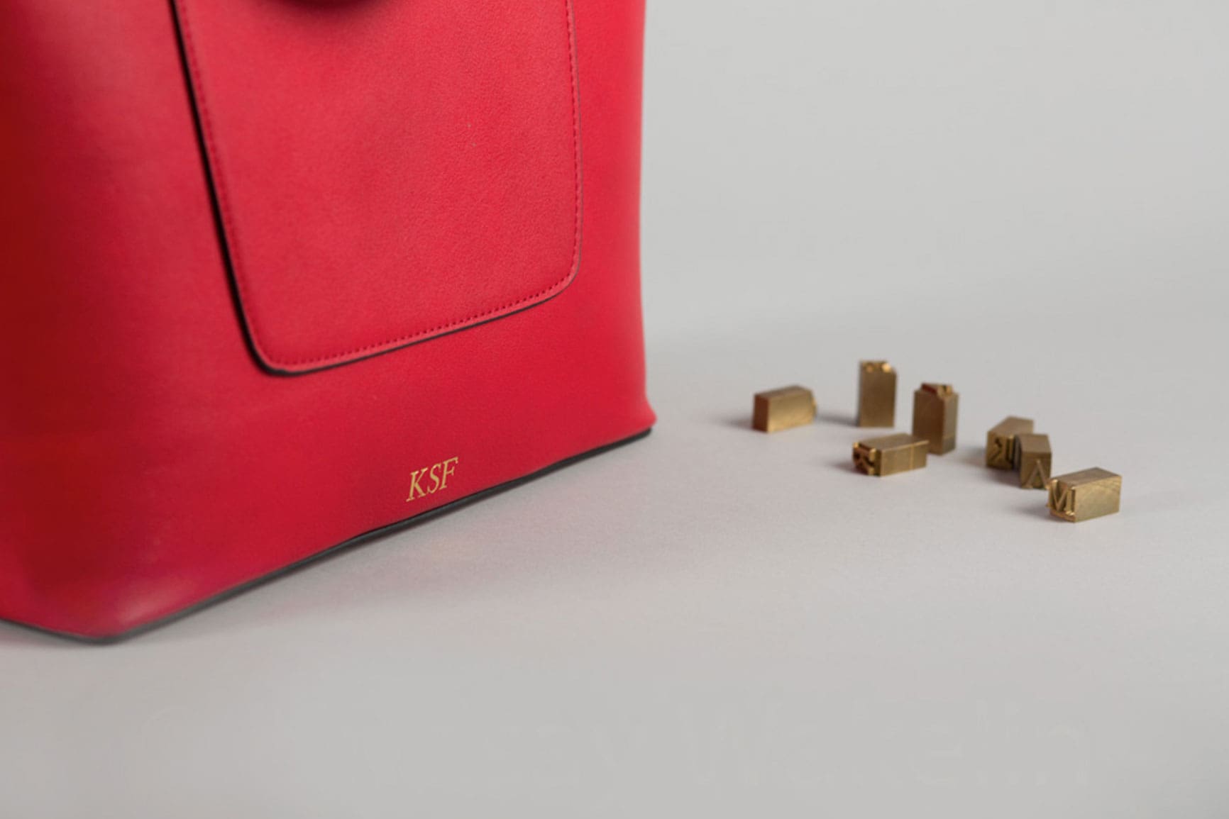 red personalised hot foil embossed handbag beside letterpress stamps